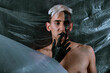 © Denis - Portrait of a young man with unusual makeup. The guy is posing without a T-shirt. Black paint on the face.
