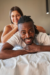 Wall Mural - Joyous young couple posing for camera in bed