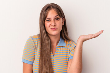 Wall Mural - Young caucasian woman isolated on white background doubting and shrugging shoulders in questioning gesture.