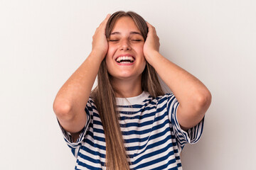 Wall Mural - Young caucasian woman isolated on white background laughs joyfully keeping hands on head. Happiness concept.