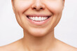 Cropped shot of a young caucasian woman with perfect white even teeth isolated on a white background. Oral hygiene, dental health care. Close-up of beautiful smile. Veneers, teeth whitening. Dentistry