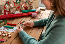 Winter Holidays And Hobby Concept - Woman With Decorated Tag Making Advent Calendar On Christmas At Home