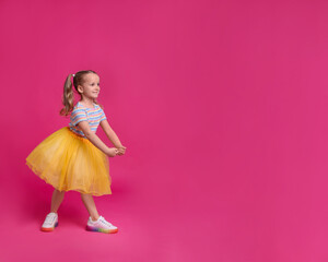 Sticker - Cute little girl in tutu skirt dancing on pink background. space for text