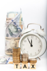 Wall Mural - 2022 tax time. money and economy concept. wooden cube blocks, money and alarm clock. isolated on white background.
