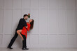 © New Africa - Lovely couple dancing under mistletoe bunch near light grey wall. Space for text