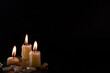 © Sergey - A few Candles isolated over dark background. Used, almost extinguished. Burned out. Copy space.