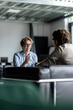 © Westend61 - Smiling businessman gesturing and discussing with colleague in lobby