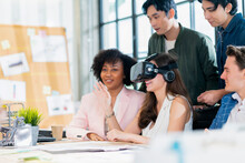 Group Of Millennial Male And Female Multiethnic Using Vr Goggle To Test Metaverse Meeting System Cheerful And Smiling,office Friend Standing Discussion Together Next To Window Office Background