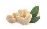 Fototapeta Lawenda - Pile of tasty organic cashew nuts and green leaves isolated on white