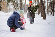 © irissca - Outdoor family activities for happy christmas winter holidays. Happy father and mother playing with little baby toddler girl daughter in winter park, forest. Happy family getting Christmas tree