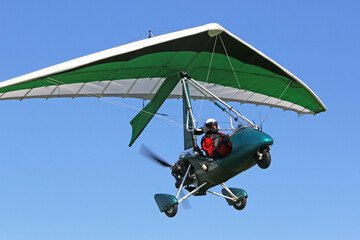 Poster - Ultralight airplane flying in a blue sky	