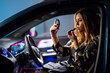 © Supermelon - Elegantly dressed blonde woman putting on makeup inside a car