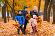 © soleg - Children playing with yellow maple leaves in autumn city park. Fall season, beautiful nature.