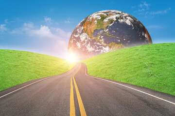 asphalt road and green grass field forward to globe on sunny day. elements of this image furnished b