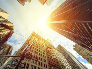 Wall Mural - Looking up at the skyline buildings of Broadway in Manhattan, New York City with sunlight shining in the sky