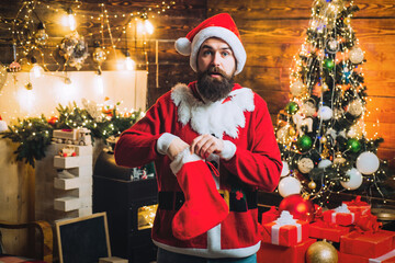 Excited Santa man posing on vintage wooden background. Surprised Santa christmas gift.