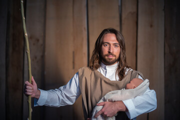 Biblical character of Joseph holding Jesus baby in a crib