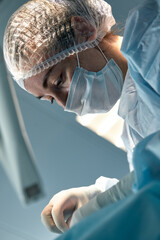 Wall Mural - Close-up of a female surgeon in an operating room, a doctor with a tense expression on his face, in an operating room.