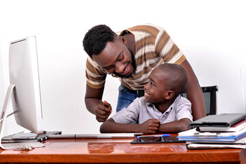 Wall Mural - young father teaches his little boy to use a laptop while smiling.