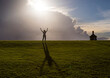 © rubchikova - Female silhouette at the top of the hill. Hands up. Big shadow from a girl