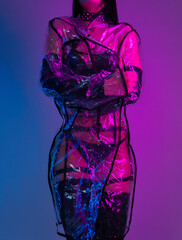 slender woman in a swimsuit and a transparent raincoat in neon light