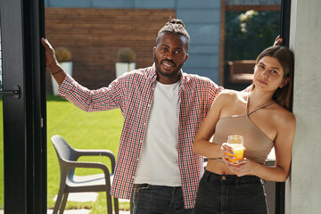 Wall Mural - Smiling guy and serene lady at open front door