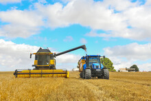 Photo Of Combine Harvester That Is Harvesting Wheat With Dust Straw In The Air.