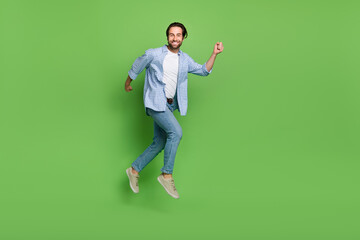 Wall Mural - Full length profile side photo of young cheerful man jumper walk isolated over green color background