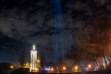 Wall Mural - Symbolic light rays and candles near the Memorial to Holodomor victims during a commemoration ceremony in Kyiv, Ukraine