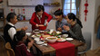 © PRPicturesProduction - cheerful asian senior woman grandmother in red clothing putting thumb up while serving her specialty on table, feeling proud of her cooking. ready to have family reunion dinner on lunar new year