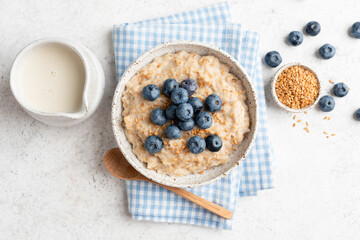 Wall Mural - Vegan oatmeal porridge with blueberries, flax seeds and soy milk