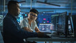 © Gorodenkoff - Teamwork In Diverse Office at Night: Project Manager Talks with Creative Solutions Specialist, They Discuss App Code Computer. Stylish Professionals Programming, Create e-Commerce Software