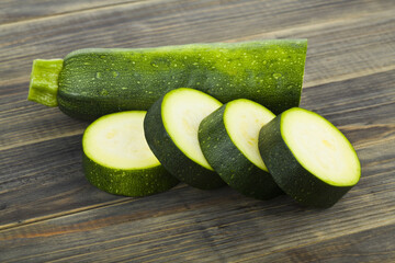 Sticker - Green zucchini on wooden background.