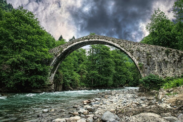 Canvas Print - Ancient stone arch bridge and mountain river	