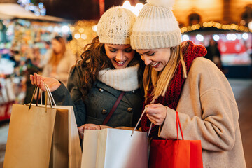 Christmas shopping people concept. Happy young women with shopping bags buying presents