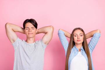 Poster - Photo of pretty dreamy young couple wear casual clothes smiling arms behind head isolated pink color background