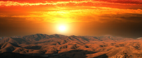 Canvas Print - Orange sun over the mountains during sunset