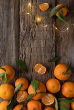 Christmas Background. Garland And Tangerines On A Wooden Background. Citruses For The Holiday.