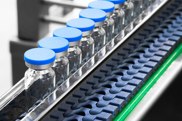 Poster - Glass bottles in production in the tray of an automatic liquid dispenser, a line for filling medicines against bacteria and viruses, antibiotics and vaccines.