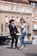 © Nikola Spasenoski - Young business colleagues dancing together with headphones after work. Happy friends jumping and fooling around outdoors