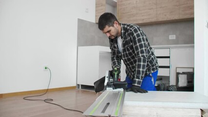 Wall Mural - A carpenter cutting a wooden board on the floor of the room