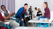 © JackF - Positive adult students communicating during recess between lectures in auditorium
