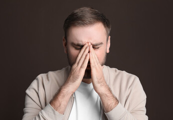 Sticker - Young man suffering from headache on dark background