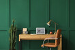 © Pixel-Shot - Modern workplace with laptop near green wall in room