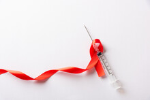 Red Bow Ribbon Symbol HIV, AIDS Cancer Awareness And Syringe With Shadows, Studio Shot Isolated On White Background, Healthcare Medicine Sexually Concept, World AIDS Day