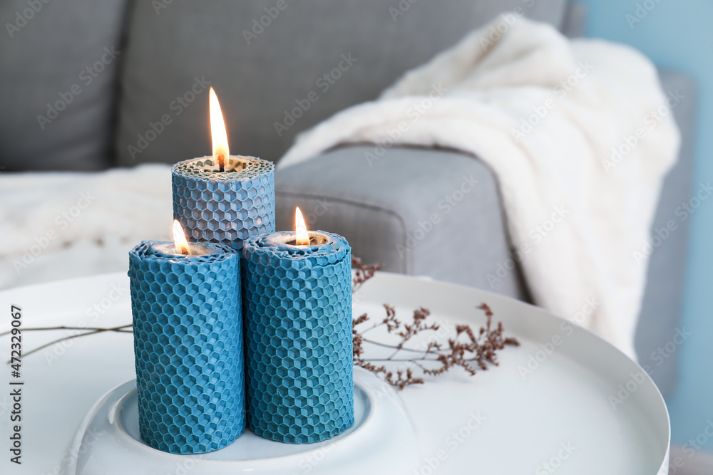 Composition with glowing candles on table in room
