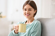 © Pixel-Shot - Beautiful young woman drinking tasty tea on sofa at home