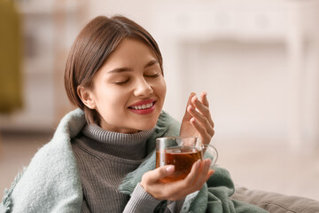 Wall Mural - Beautiful young woman drinking tasty tea at home