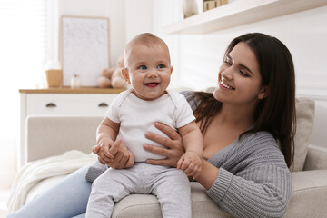 happy young mother with her cute baby in living room