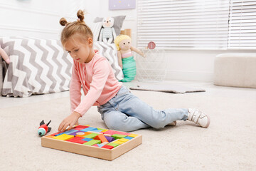 Poster - Cute little girl playing with colorful building blocks at home